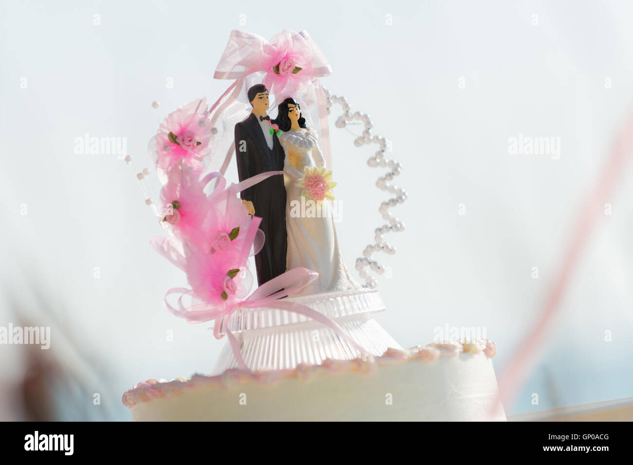 Doll weds of the bride and groom on a wedding cake that symbolizes the commitment to love one another. Stock Photo