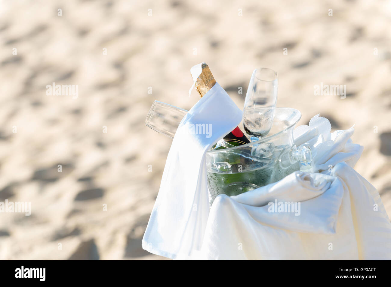 Chilled champagne and wine glasses in bucket setup on the beach. Closeup. Stock Photo