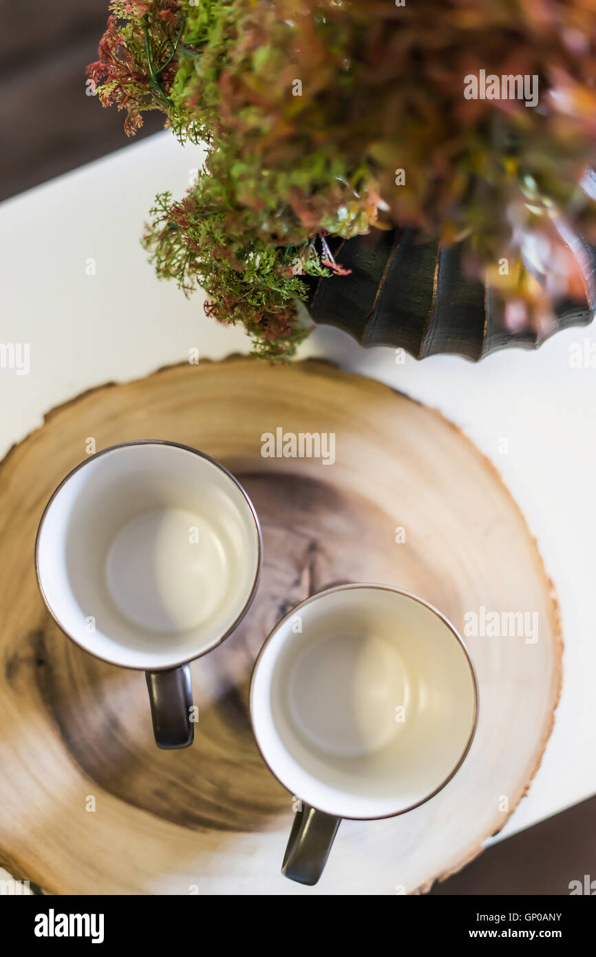 House decoration, two cups and plastic plants on white desk. Stock Photo