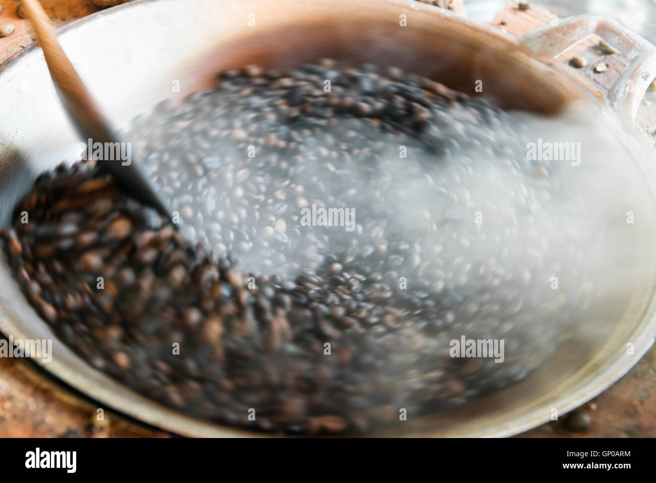 Traditional roasting coffee beans in pan, motion blur. Stock Photo