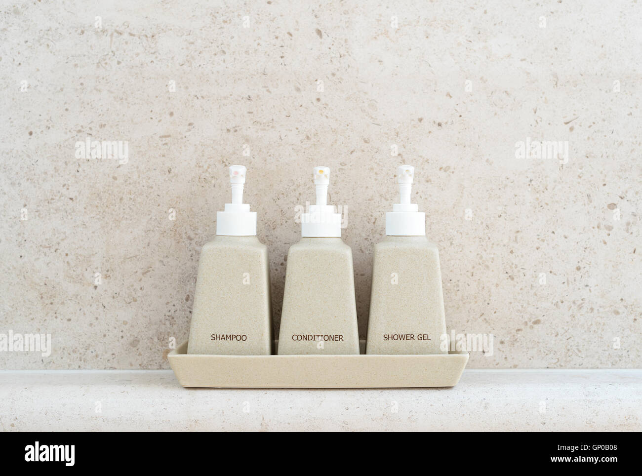 Toiletries tube in a luxury hotel, shower gel, shampoo and hair conditioner in ceramic ware. Copy space. Stock Photo