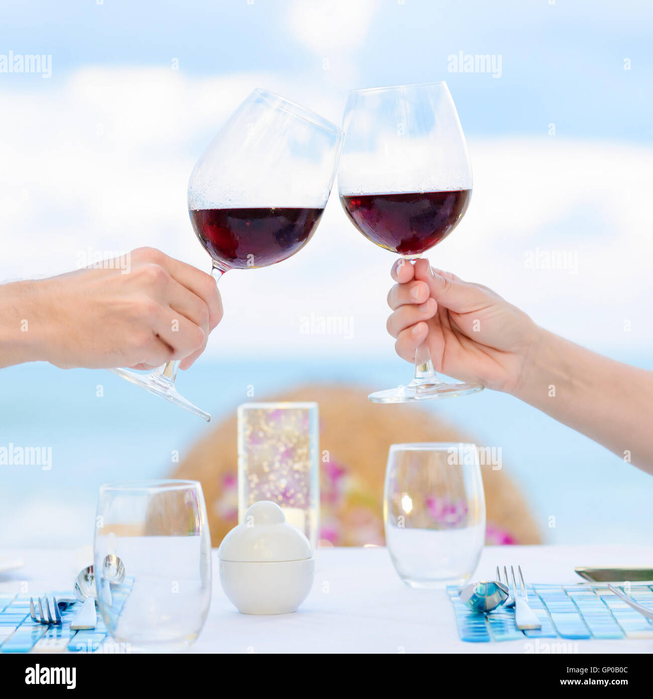 Couple drinking wine in romantic dinner on twighlight, closeup. Selective focus, shallow depth of field. Stock Photo