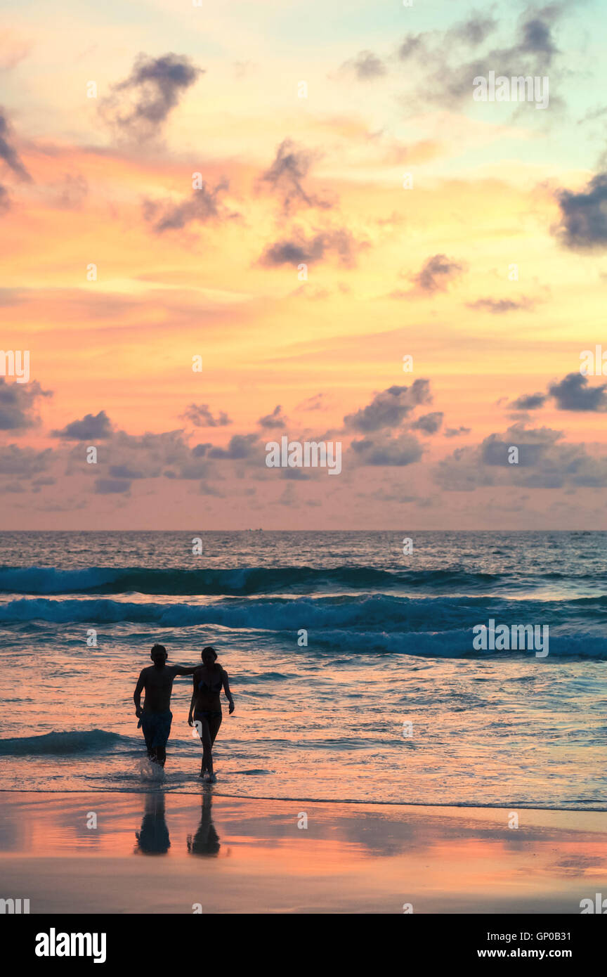 Seascape, beautiful sunset beach with silhouette couples walking. Stock Photo