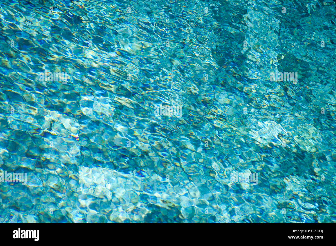 colorful water surface with sun reflections. Ideal swimming pool, sea and ocean texture. Stock Photo