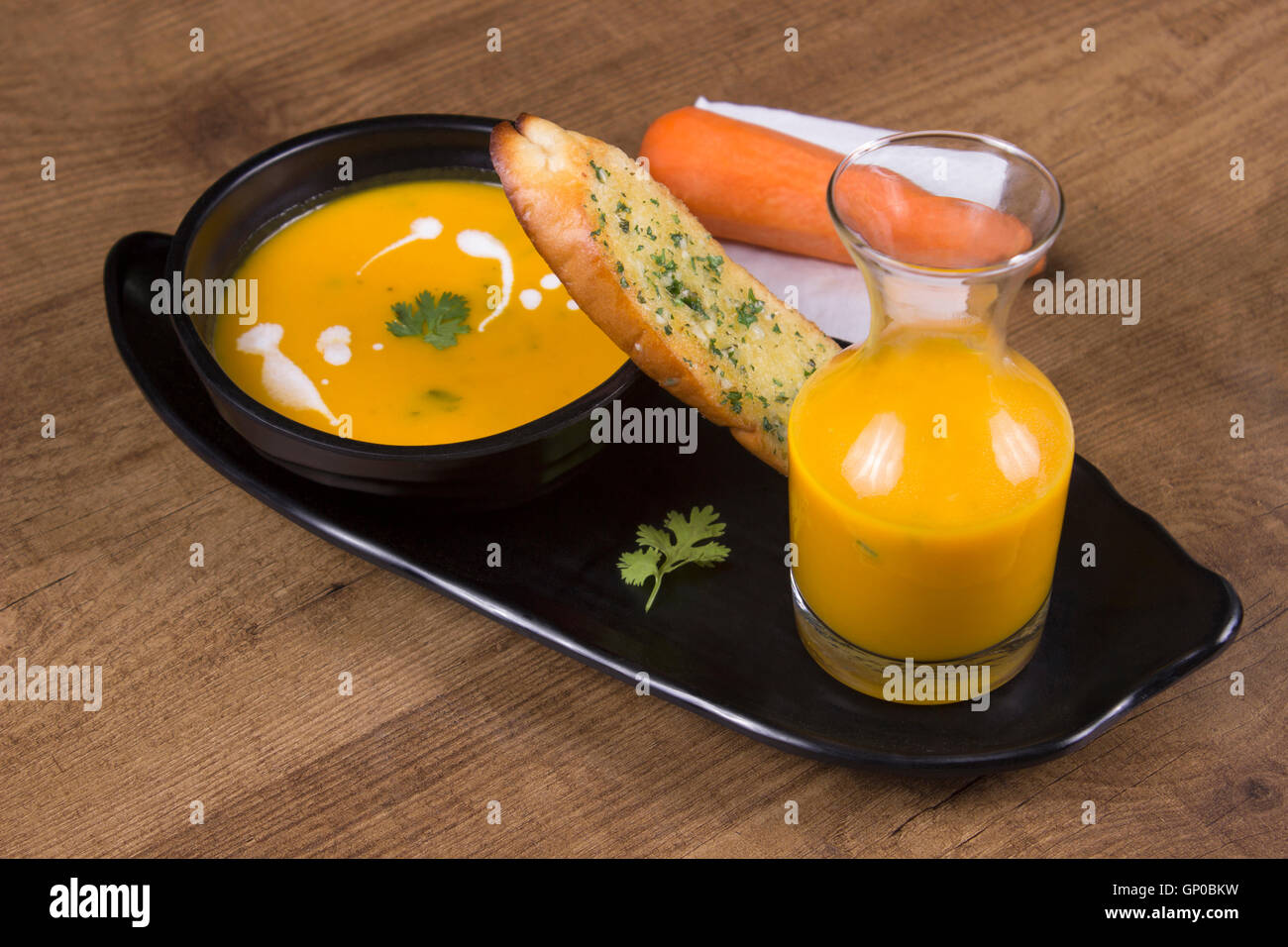 Carrot and coriander soup with garlic bread Stock Photo Alamy