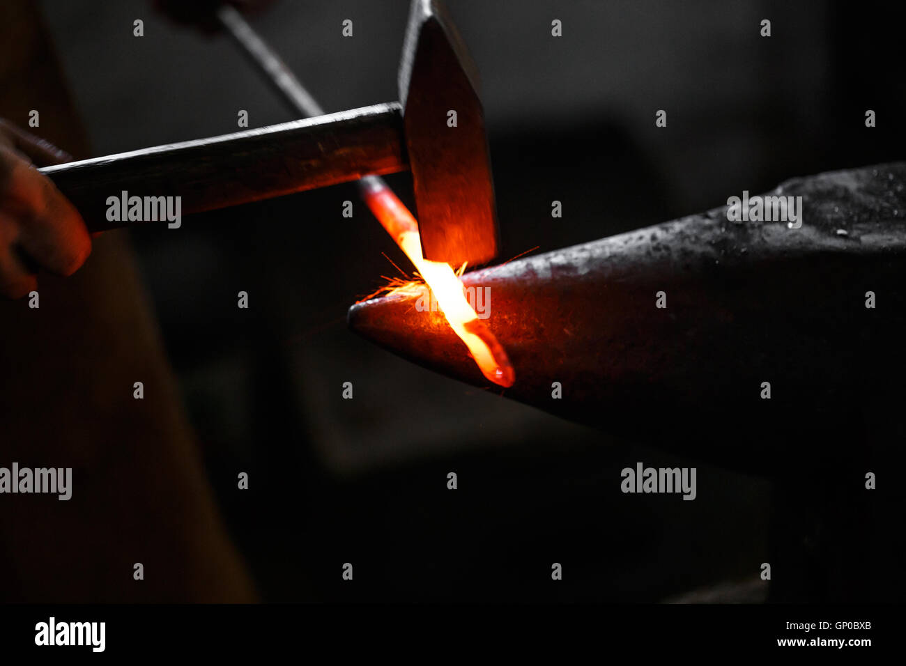 Black smith, Ironsmith hitting hotsteel on an anvil in a retro smithy