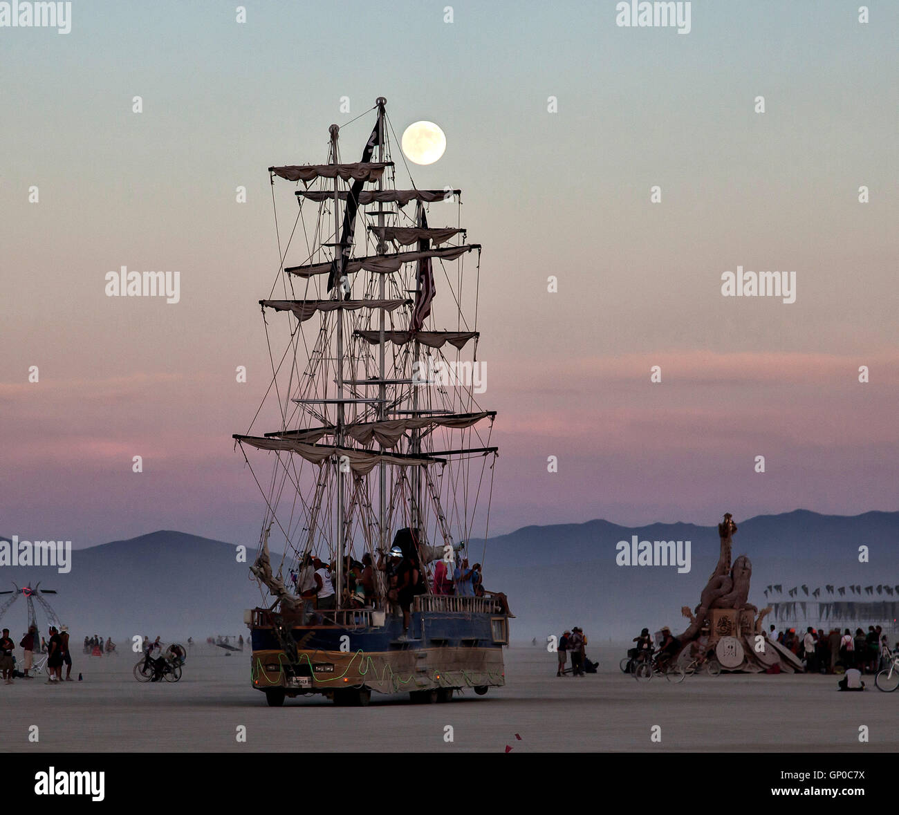 A tall sailing ship art vehicle during a sunset at the annual desert festival Burning Man August 30, 2016 in Black Rock City, Nevada. The annual festival attracts 70,000 attendees in one of the most remote and inhospitable deserts in America. Stock Photo