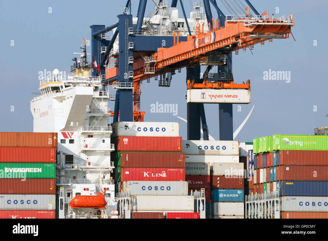 Crane operator placing a container in a cargo ship the Port of Rotterdam. Stock Photo