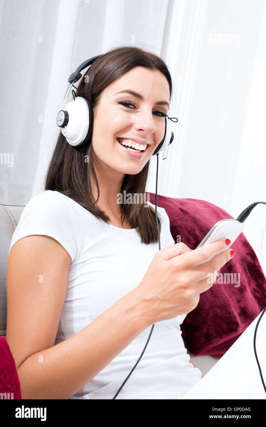 Portrait of a beautiful young woman in headphones listening to music ...
