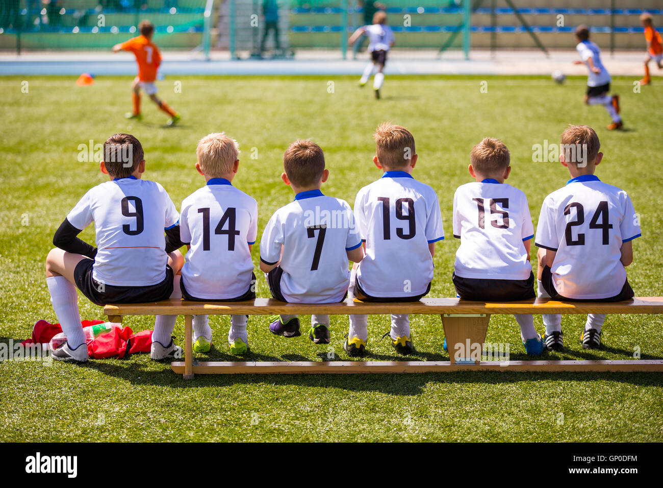 Football soccer match for children. Kids waiting on a bench. Soccer Tournament for youth school teams Stock Photo
