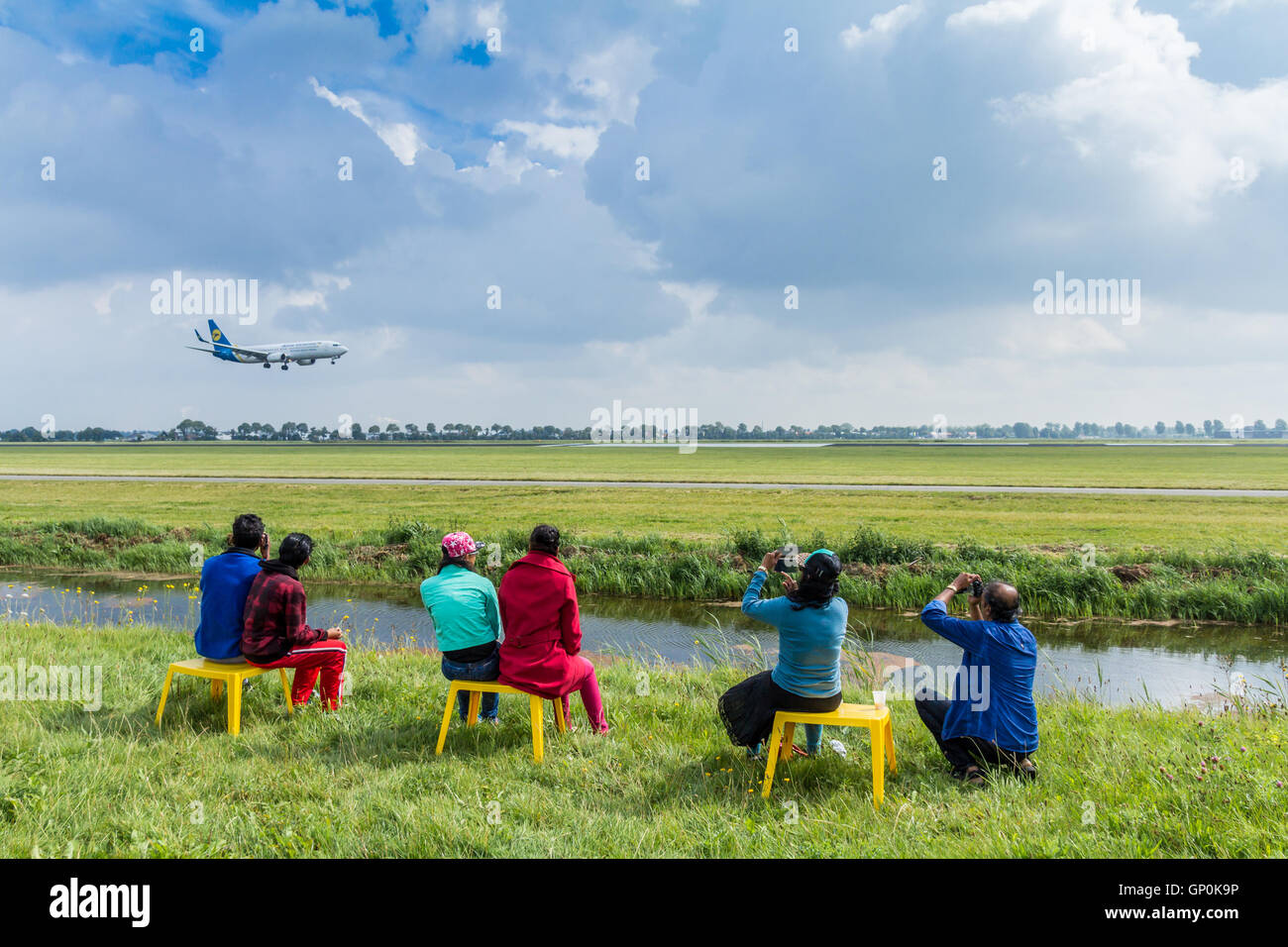 Polderbaan Vijfhuizen, the Netherlands - August 20, 2016: family of plane spotters watching passenger jet land Stock Photo