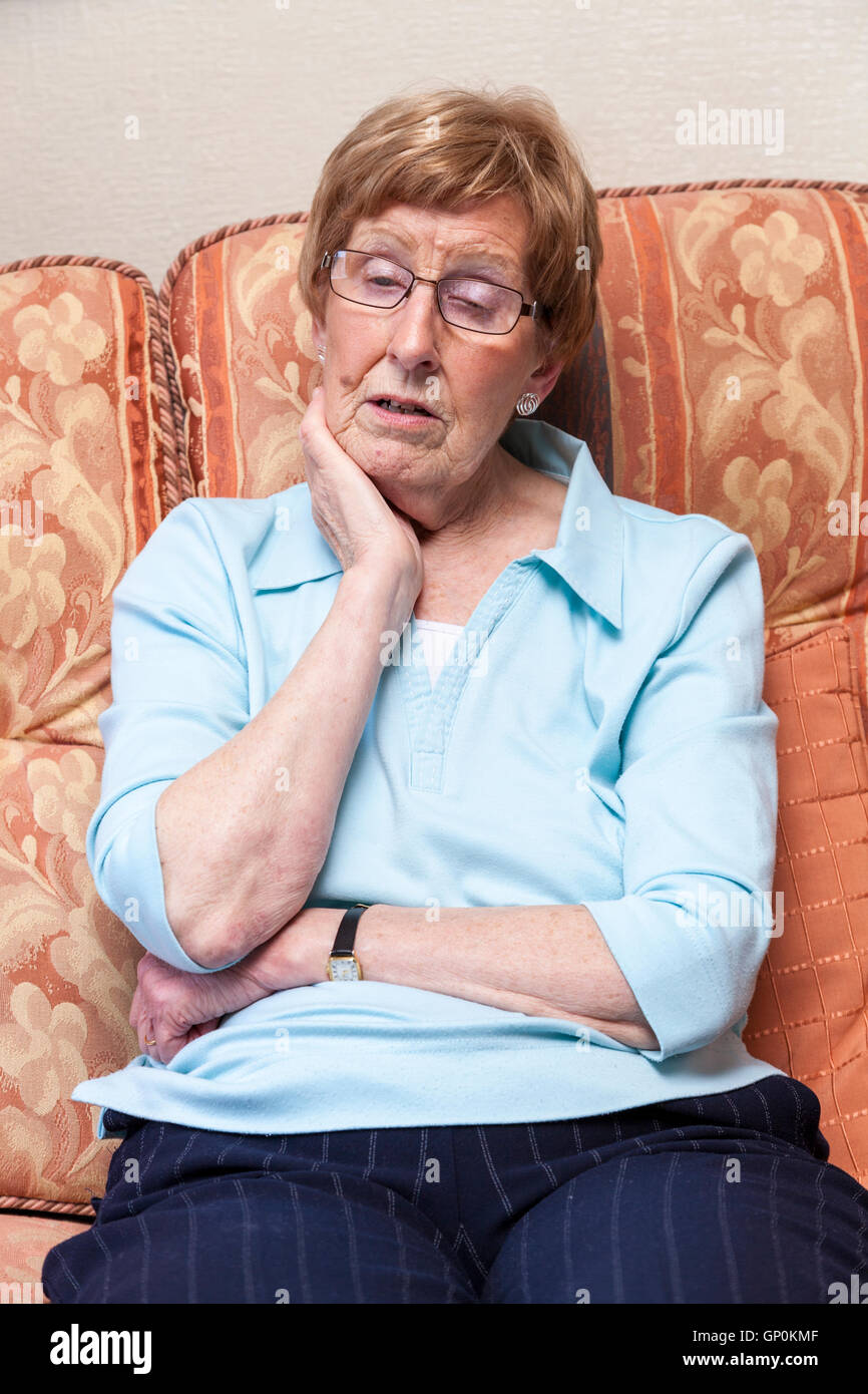 Tired older woman. Elderly person feeling sleepy while sitting on a