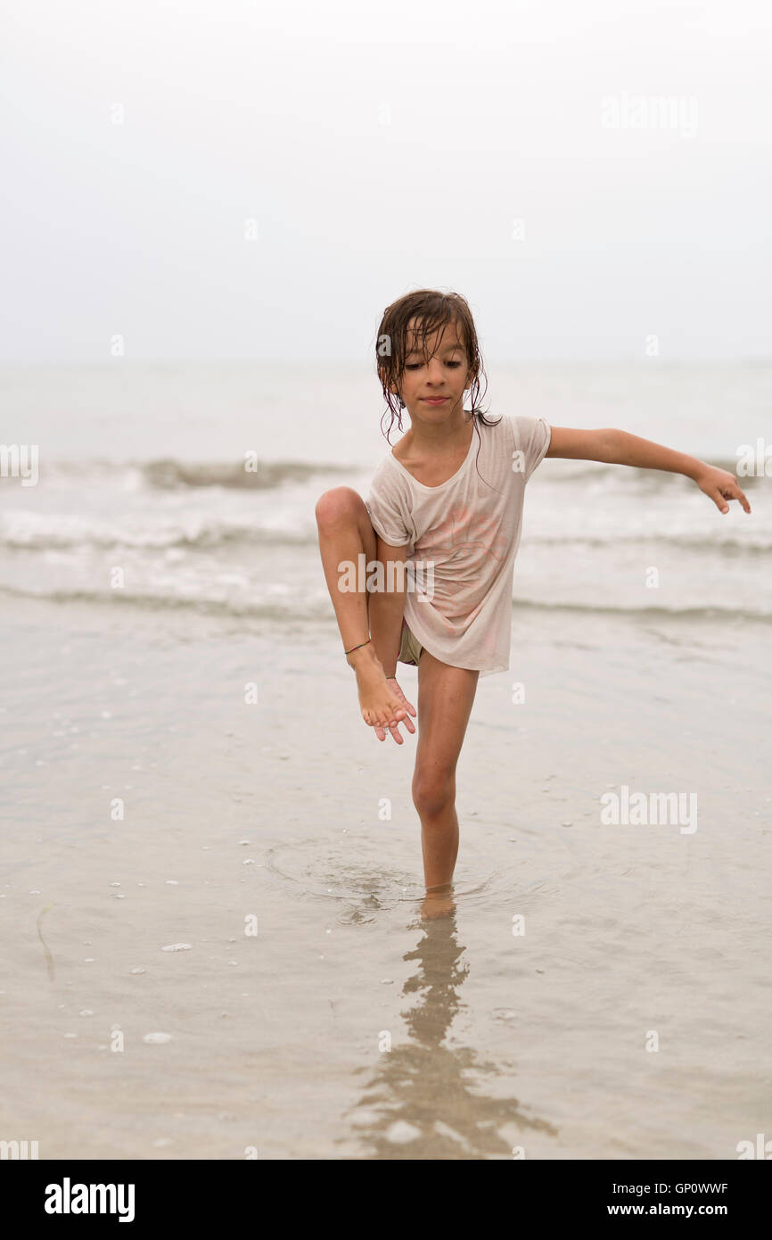 Little girl on a beach doing water gymnastics Stock Photo Alamy