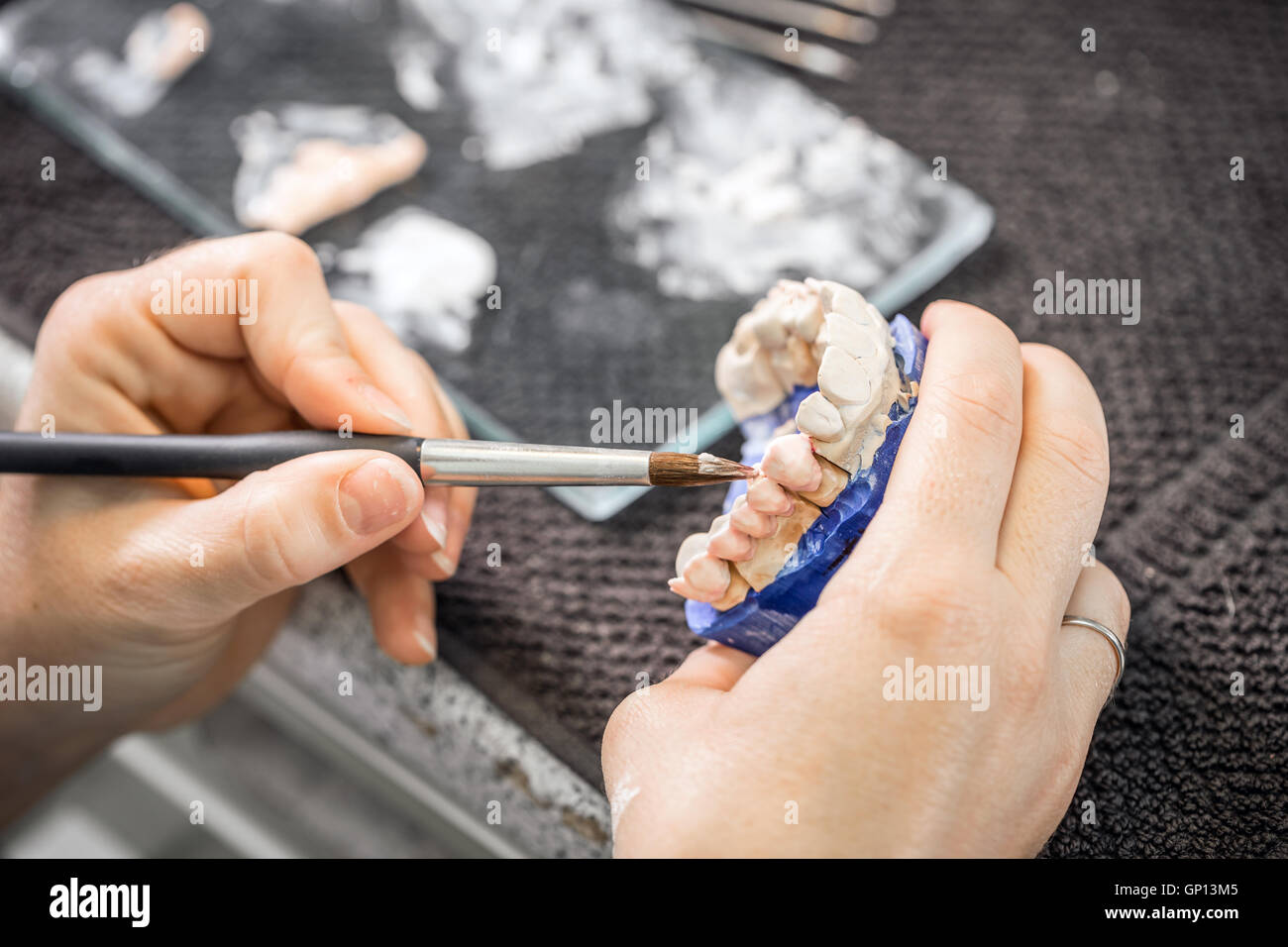 Dental technician working with tooth dentures at prosthesis laboratory Stock Photo