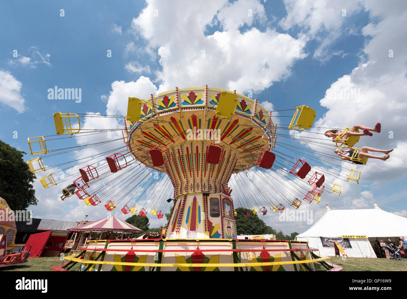 Young people enjoying ride on flying chairs fairground ride at Stow cum ...