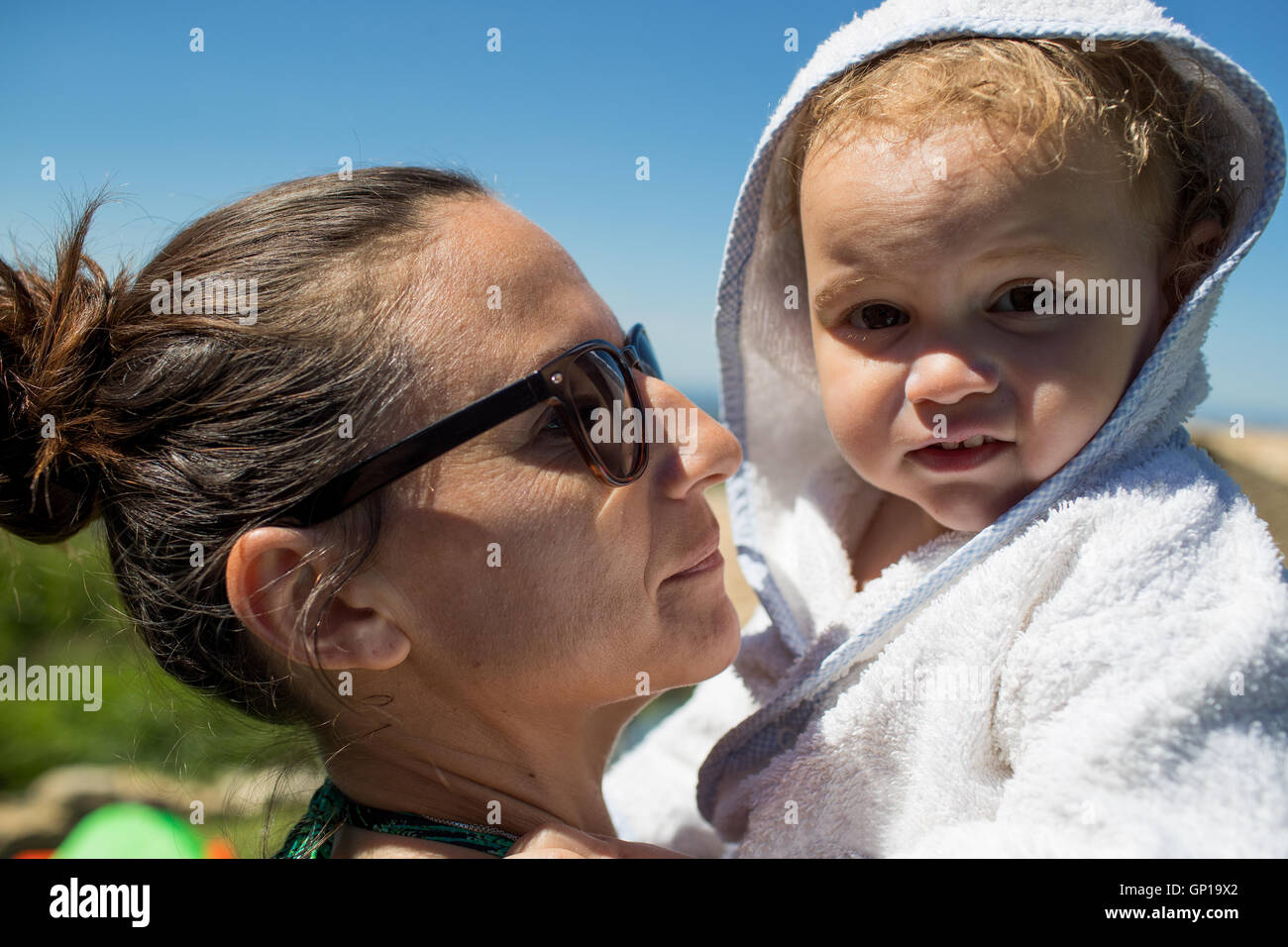 Portrait of baby in bathrobe with mother Stock Photo