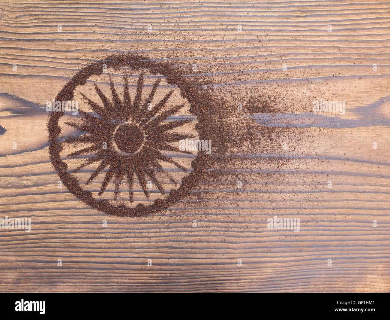 Indian tea powder in the form of Ashoka Chakra on the textured wooden board Stock Photo