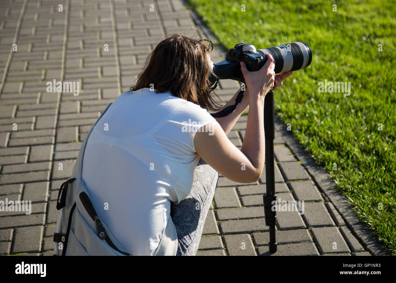 The camera is mounted on a monopod and photographer behind 2016 green