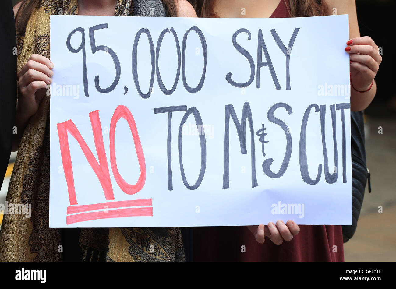 A group gathers outside Marks and Spencer's flagship store in Oxford Street, London, to hand in a petition calling on the high street giant to scrap proposed pay cuts to offset the cost of the National Living Wage. Stock Photo