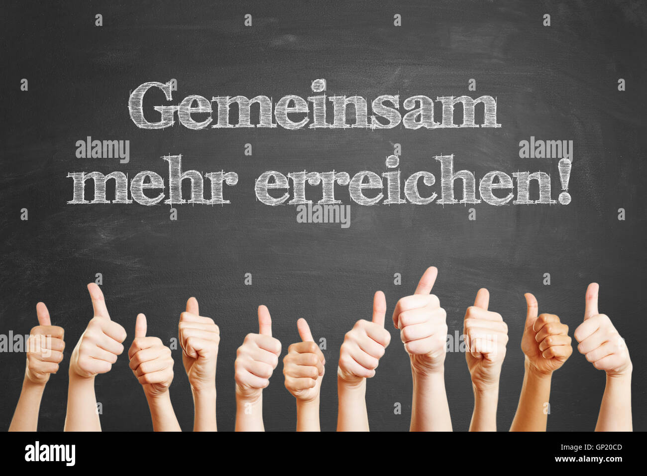 German slogan 'Gemeinsam mehr erreichen' (Together we achieve more) on chalkboard Stock Photo