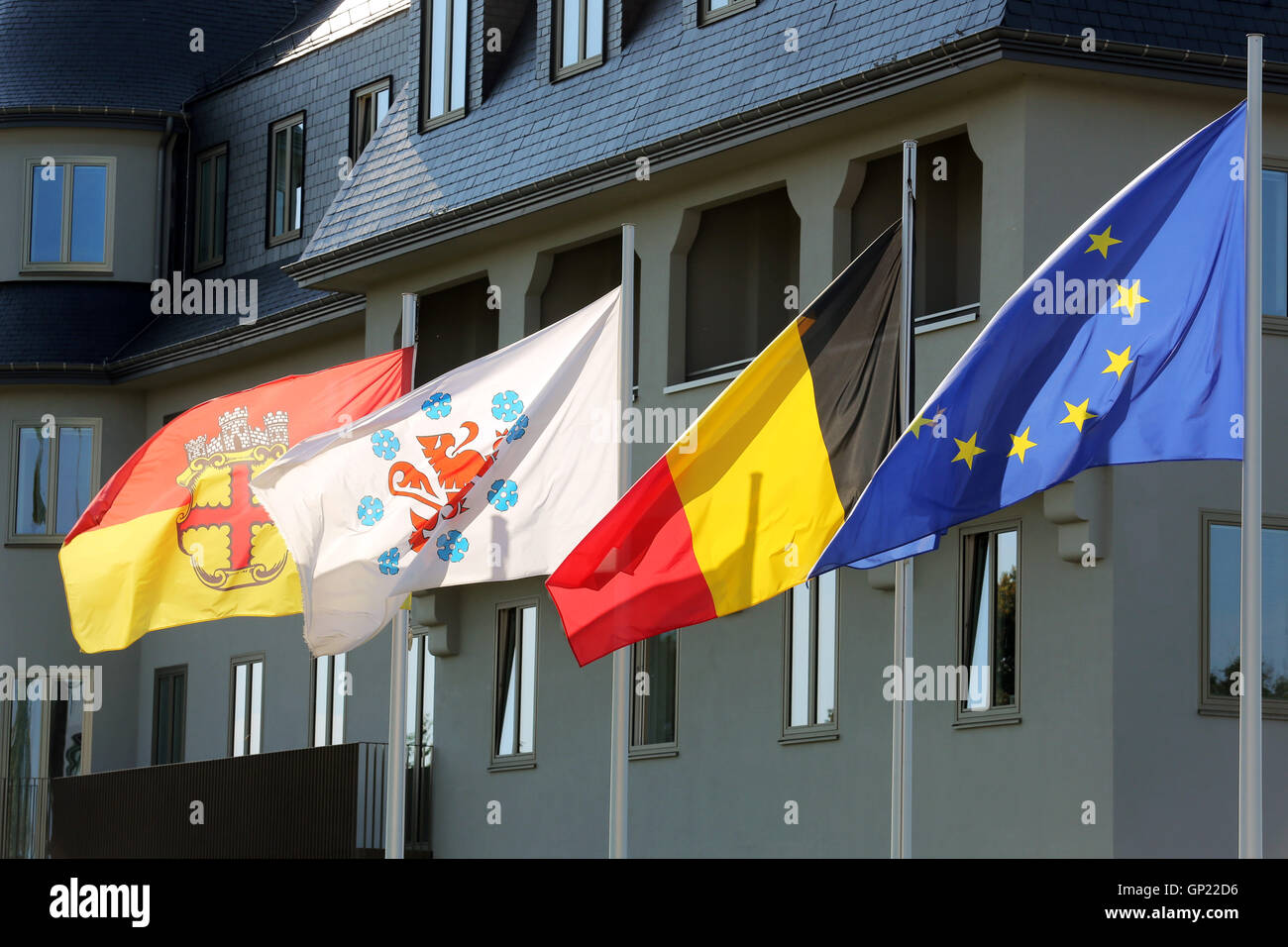 Parliament building of the German speaking Community in Eupen, Belgium. Flags from left to right: City of Eupen, German-speaking Community, Belgium, Europe Stock Photo