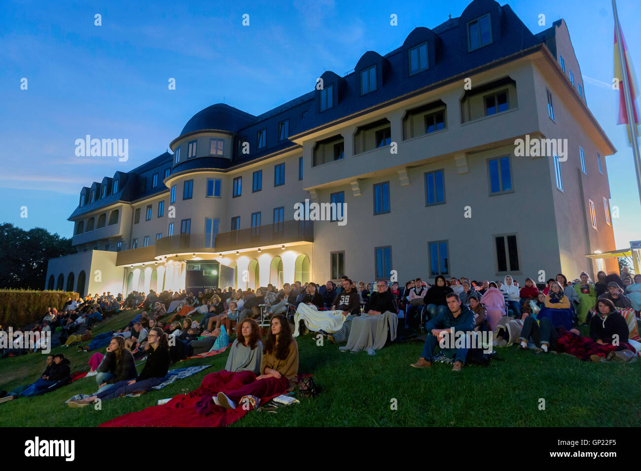 Spectators at an open-air movie night in front the Parliament building of the german-speaking Community in Eupen, Belgium. Stock Photo