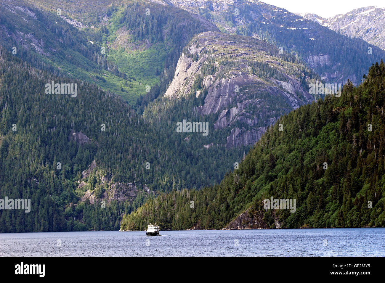 Small boat cruise ship large mountain range Misty Fjords National Monument Inside Passage Southeast Alaska USA Stock Photo