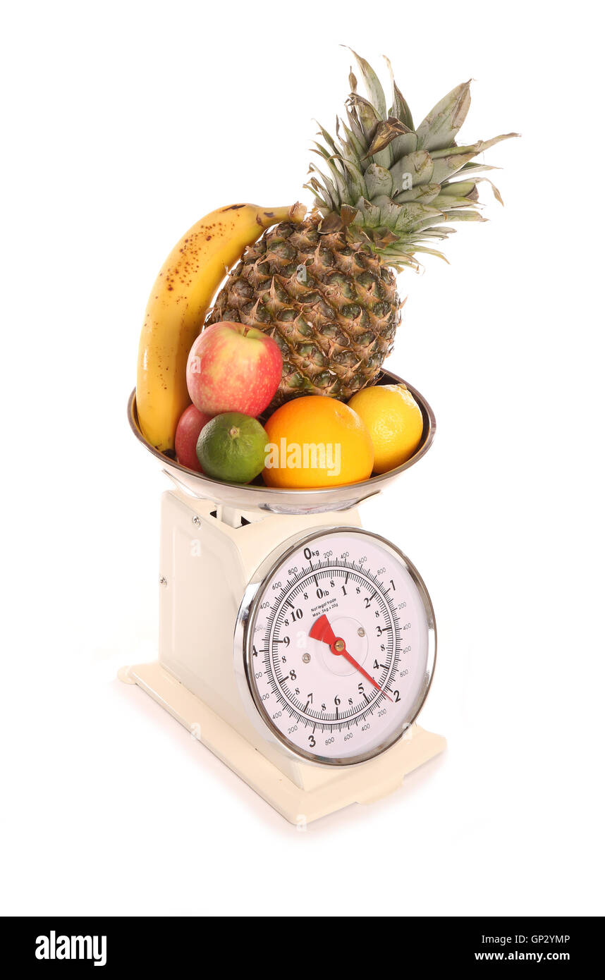 Balanced diet fruit on weighing scales cutout Stock Photo