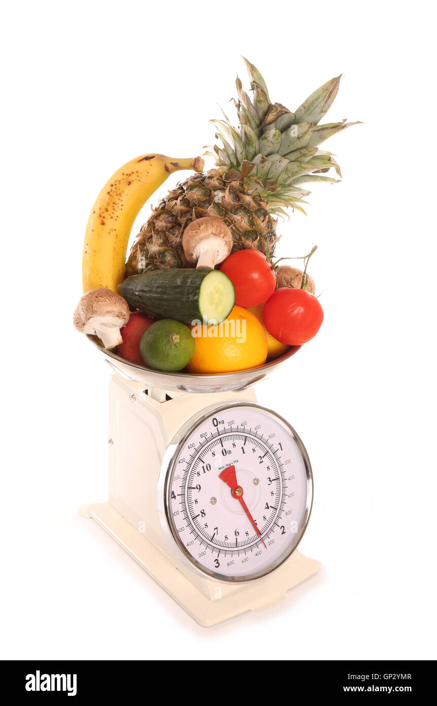 Balanced diet fruit and vegetables on weighing scales Stock Photo
