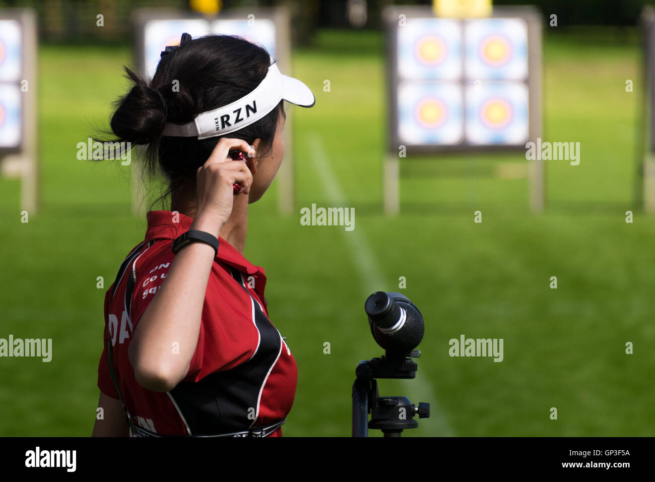 Young female compound archer and target in competition Stock Photo