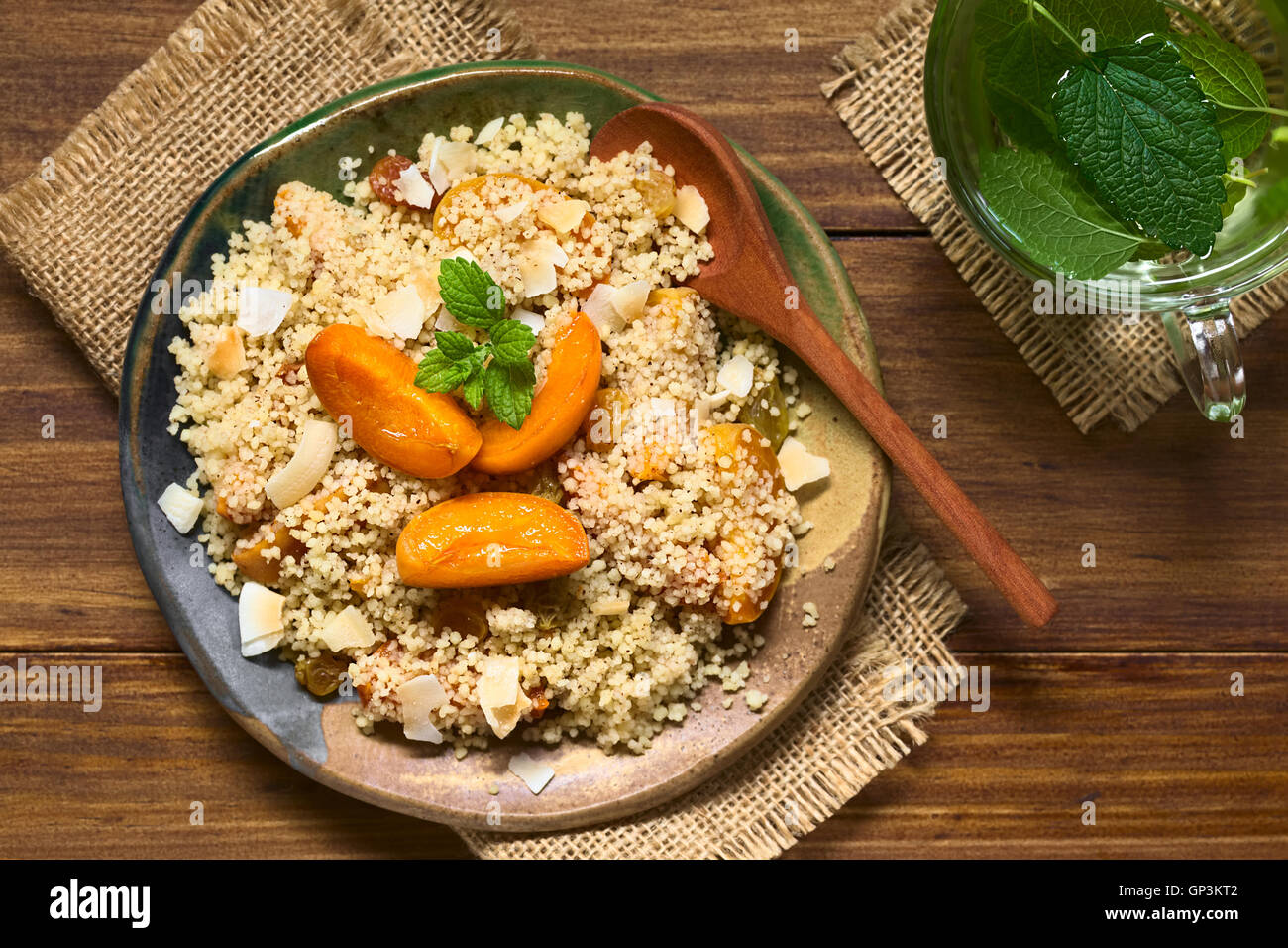 Couscous dessert with apricots, yellow raisins, coconut flakes and cinnamon garnished with lemon