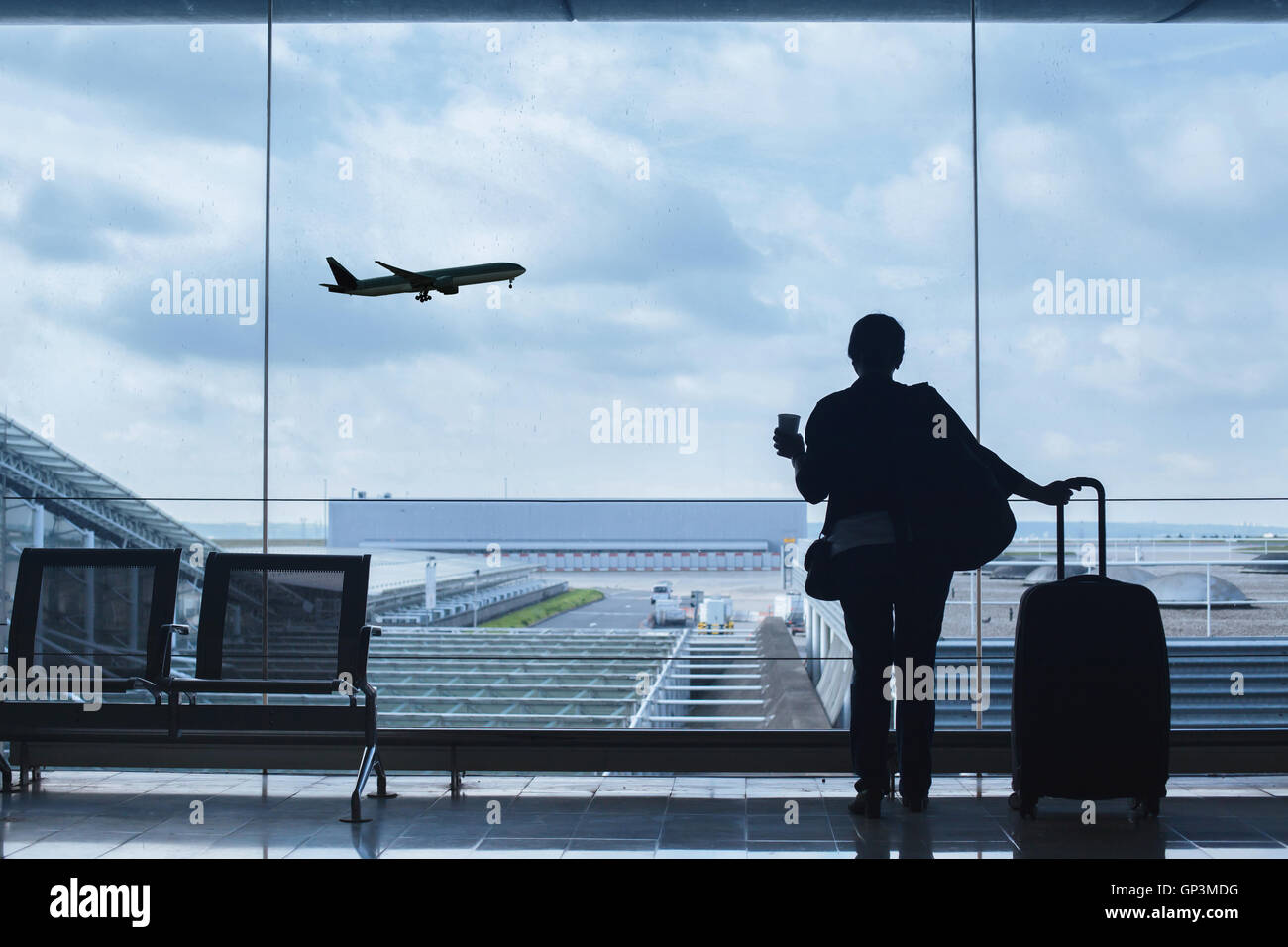 traveler in airport looking at the plane taking off Stock Photo
