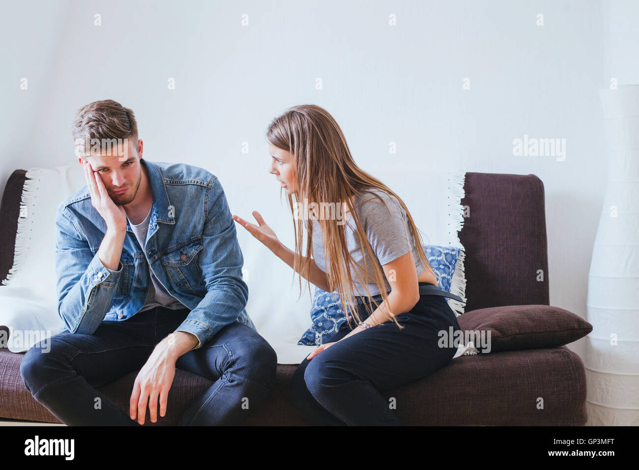 relationship problems in young family, angry woman wife and tired indifferent man husband Stock Photo