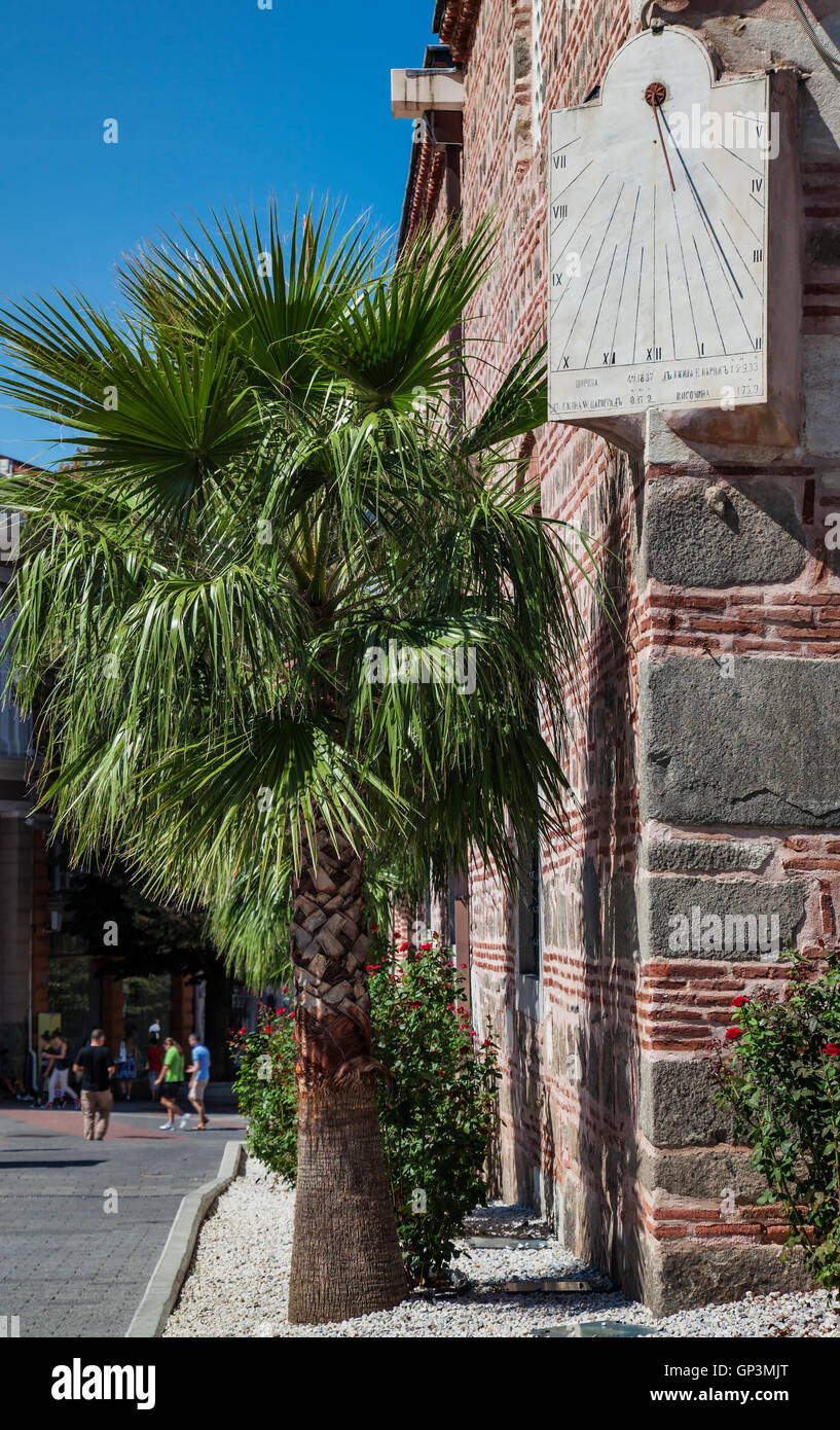 Sun clock and a palm tree on the corner of Dzhuaya, Djumaya Mosque or Cuma Camii in turkish, downtown Plovdiv on a sunny summer Stock Photo