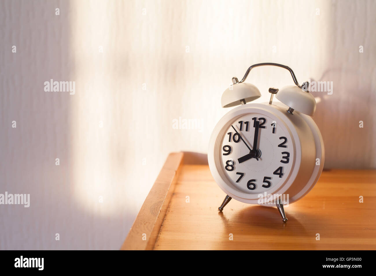 eight o'clock in the morning, alarm clock on bedside table Stock Photo