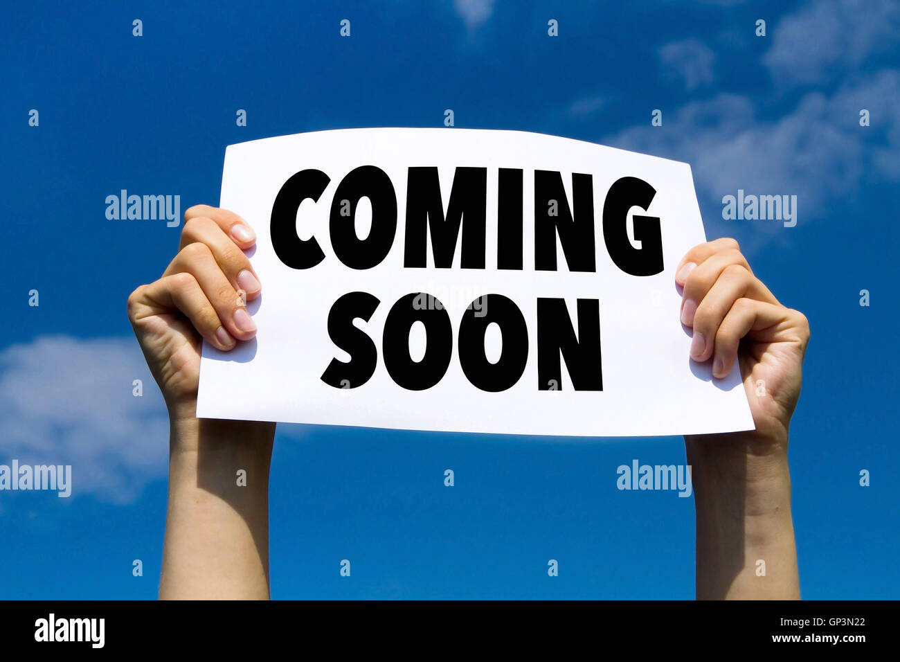 coming soon, message note, hands holding paper sign with announcement Stock Photo