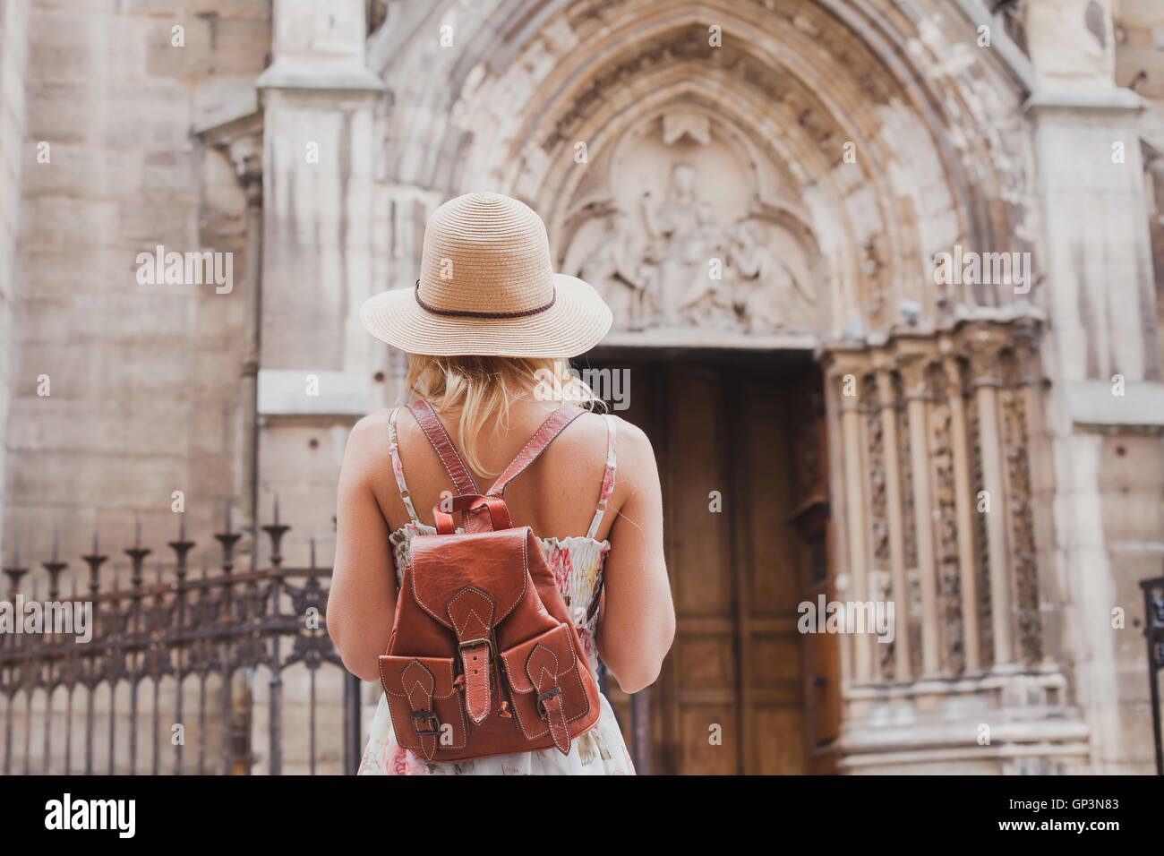 tourist travels in Europe, sightseeing tour, back of woman with backpack looking at historical architecture Stock Photo