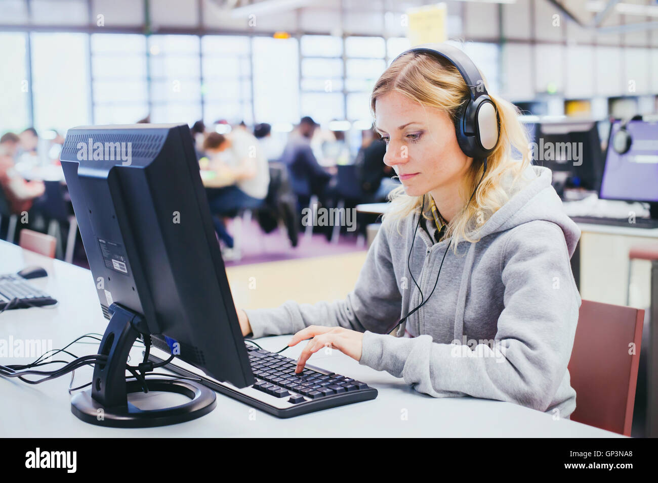 adult education, middle aged woman studying on computer in modern library Stock Photo