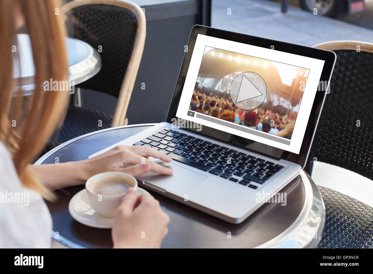 video streaming, online concert, woman watching live music clip on internet on laptop in cafe Stock Photo