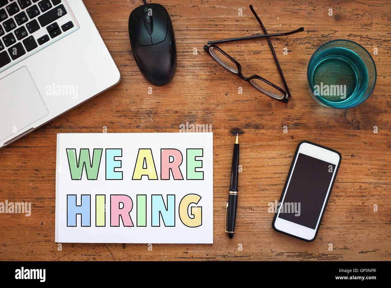 we are hiring, sign in notepad, wooden background Stock Photo