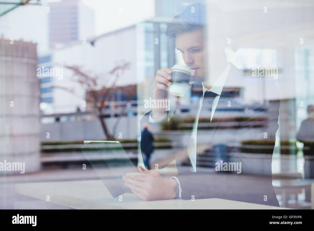 businessman reading news online and drinking coffee in airport cafe Stock Photo