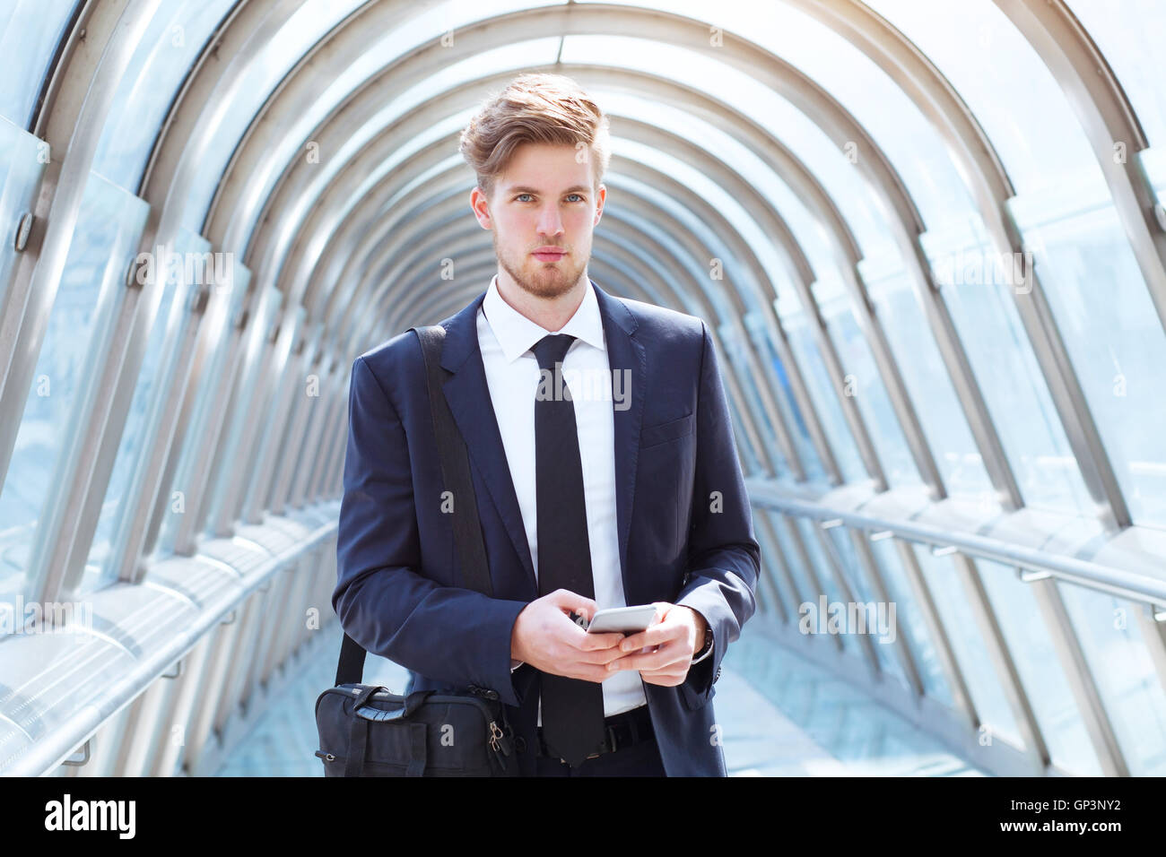 businessman walking in modern office corridor, portrait looking at the