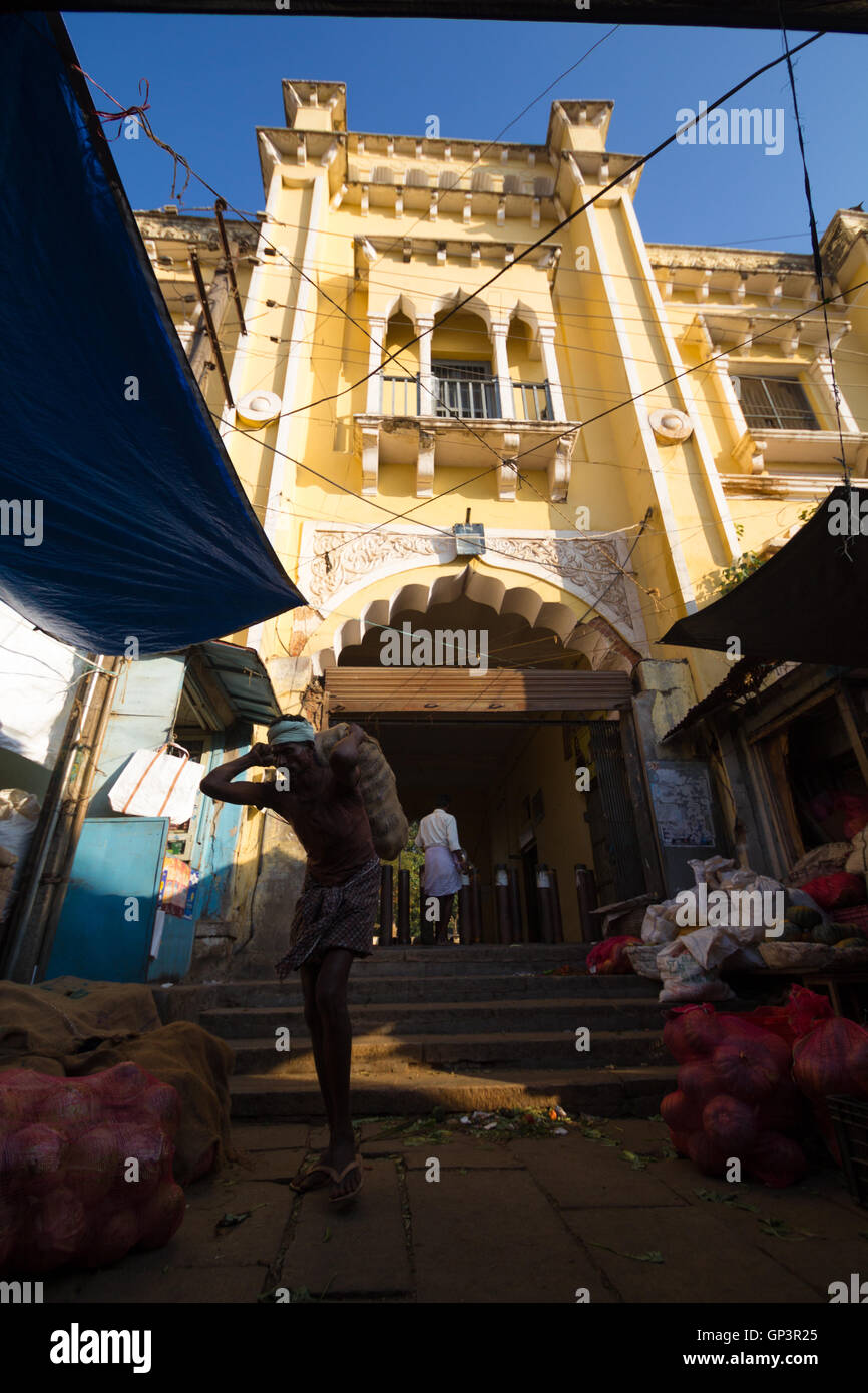Head load workers unloading veget bags in the Devaraja market in Mysore, India. Head load workers are an organised work force. Stock Photo