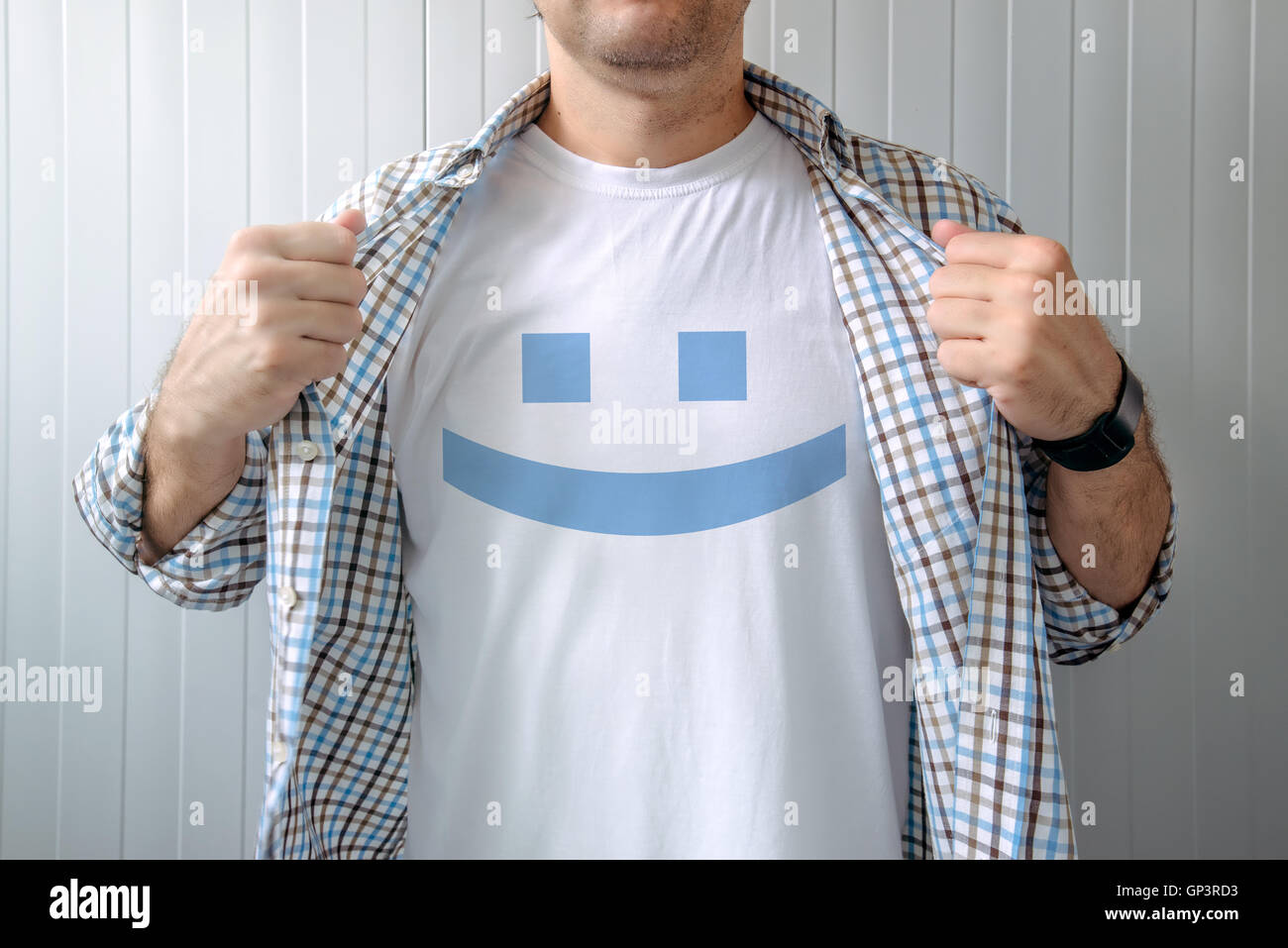 Man stretching shirt to reveal smiley emoticon printed on chest Stock Photo