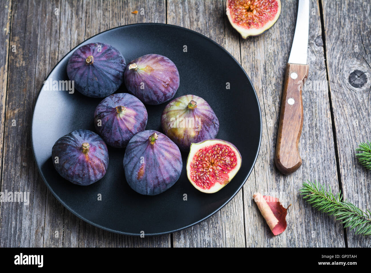 Figs on black plate on wooden table background Stock Photo