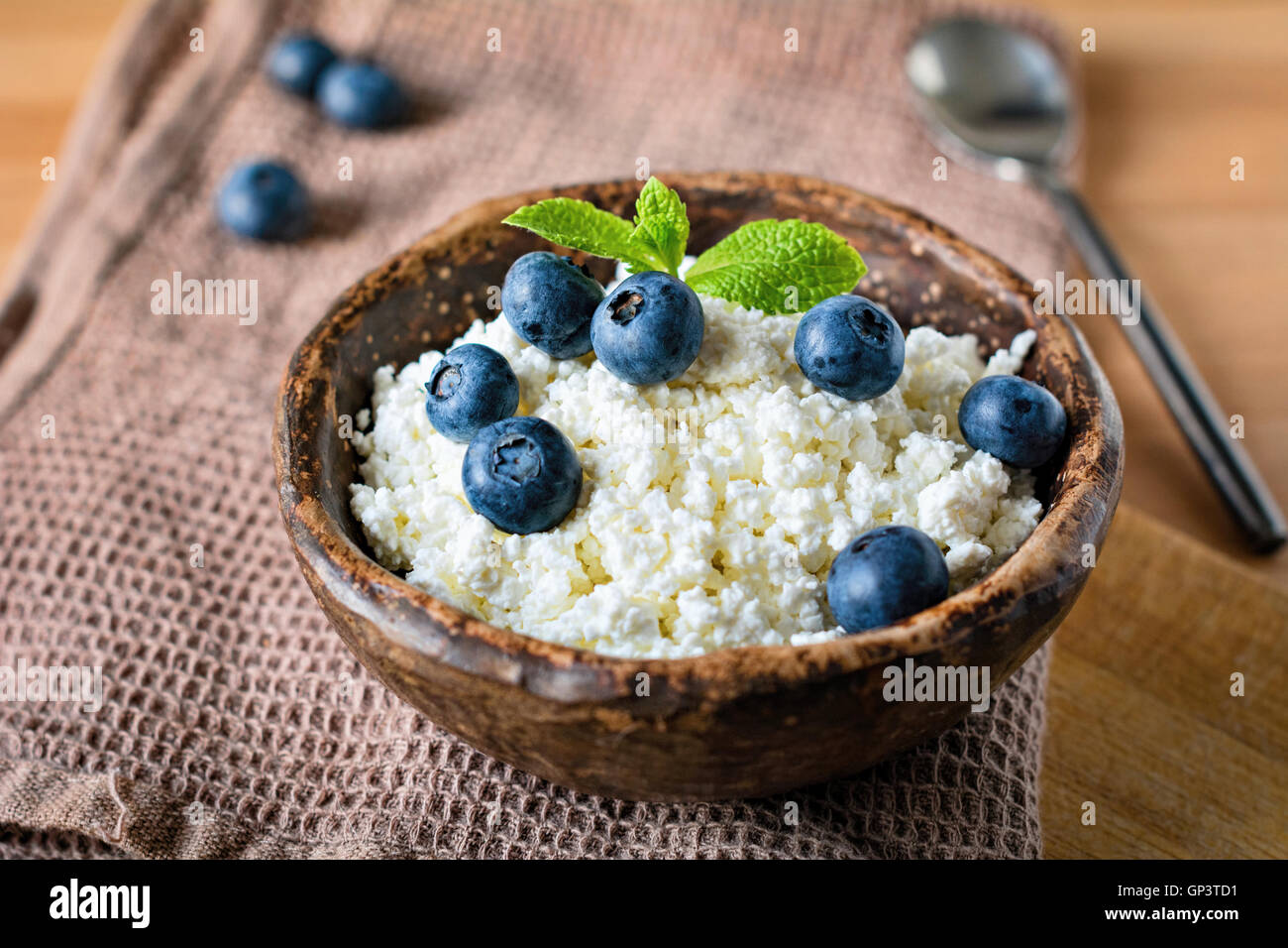 Farmers cheese, cottage cheese or quark - healthy homemade dairy product for breakfast. Topped with blueberries and mint leaf Stock Photo