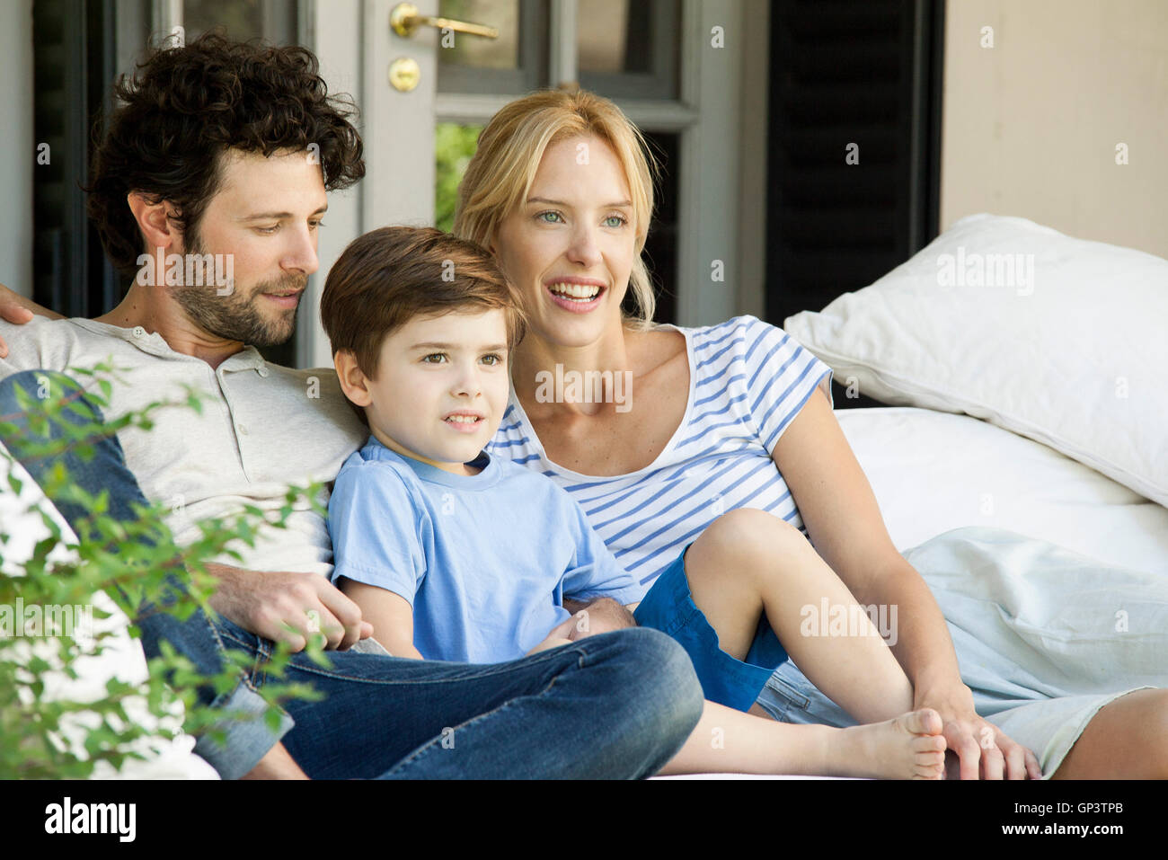 Family with one child relaxing together outdoors Stock Photo