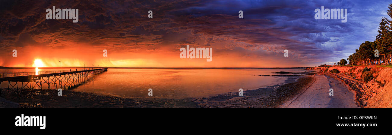 panoramic view of Ceduna town bay from timber jetty to elevated beach side with trees at sunset during remote storm. Cloudy over Stock Photo
