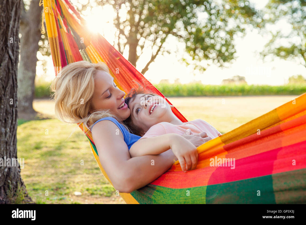 Mother and son relaxing in hammock together Stock Photo