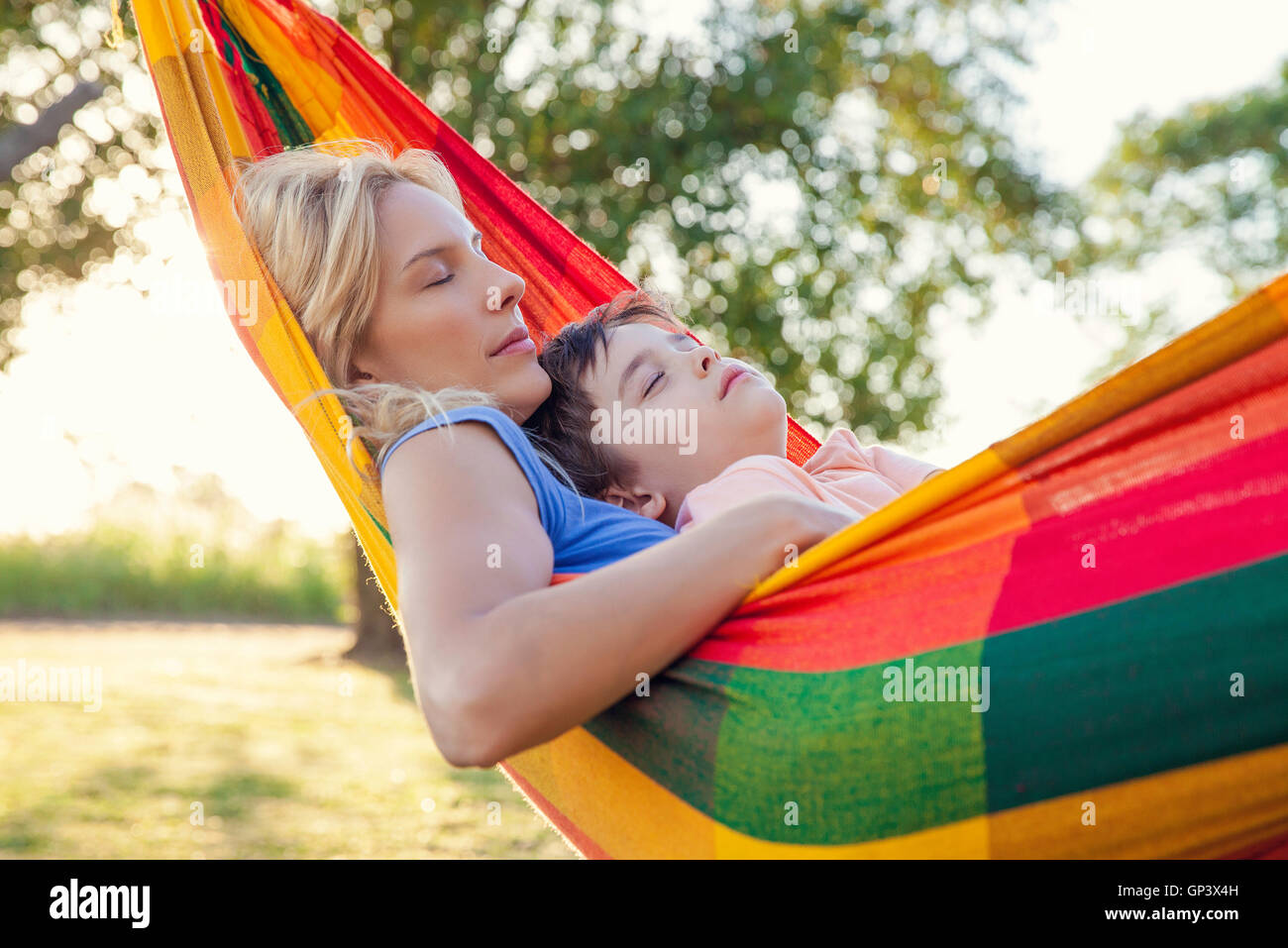 Mother and son napping together in hammock Stock Photo